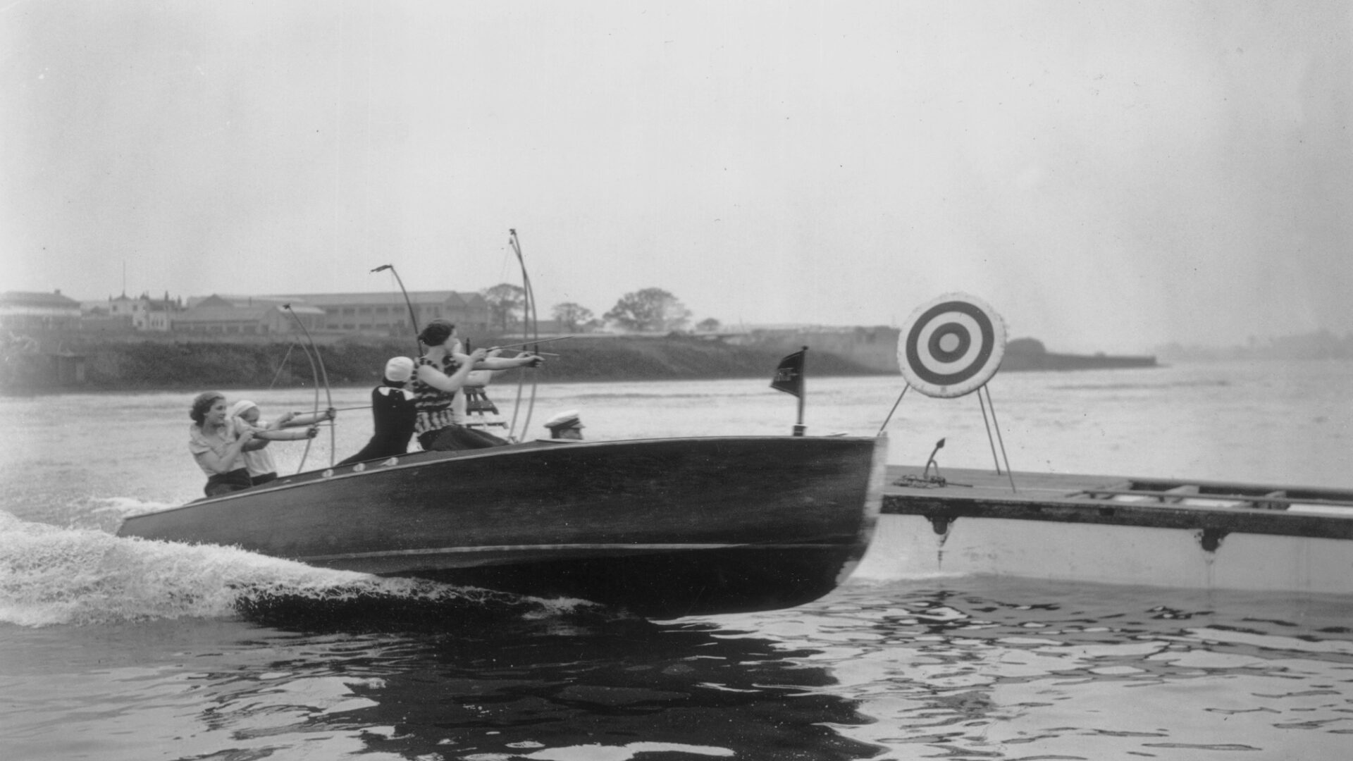 20th May 1932: Archery experts shooting arrows at a target from a speed boat at the Welsh Harp in Hendon, North West London near Brent Cross Town (Brent Cross Town)