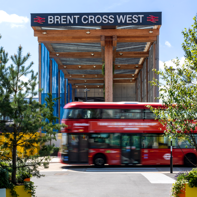 Photo of Brent Cross West station in North London with a red bus in the foreground. (Brent Cross Town)