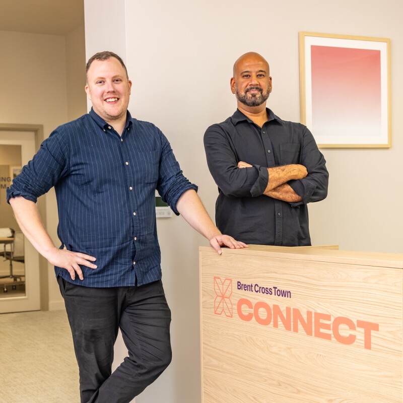 A photo of two members of the Connect team standing by a desk which read 'Brent Cross Town Connect'. (Brent Cross Town)
