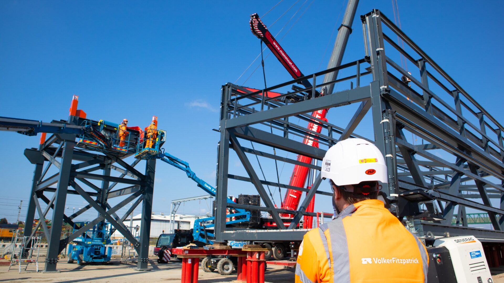 Man in hard hat watching supports of bridge being put into place (Brent Cross Town)