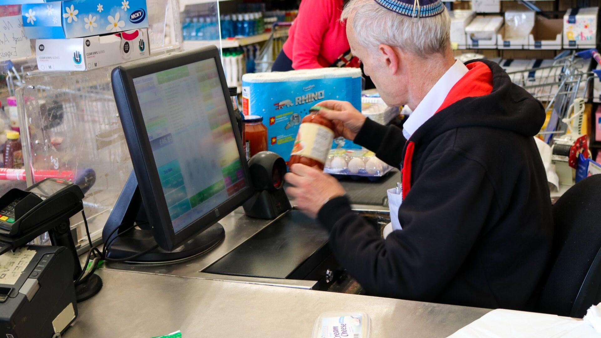 server at the checkout of Kosher Outlet supermarket in Brent Cross Town (Brent Cross Town)