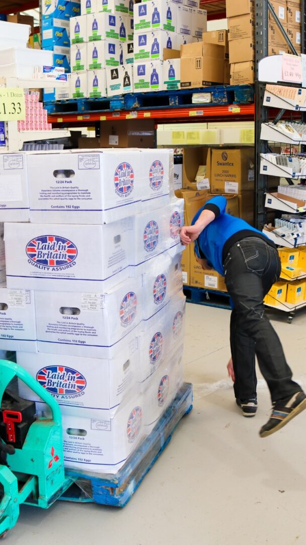 Kosher Outlet at Brent Cross Town, man moving stack of goods between aisles (Brent Cross Town)