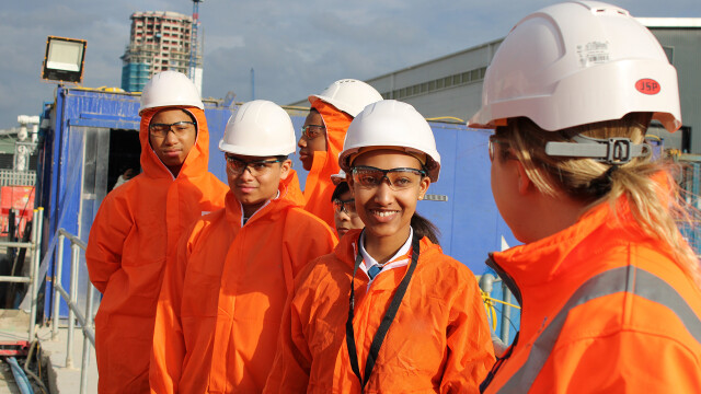 Photo of a group of smiling young people wearing hard hats and high-vis jackets. (Brent Cross Town)