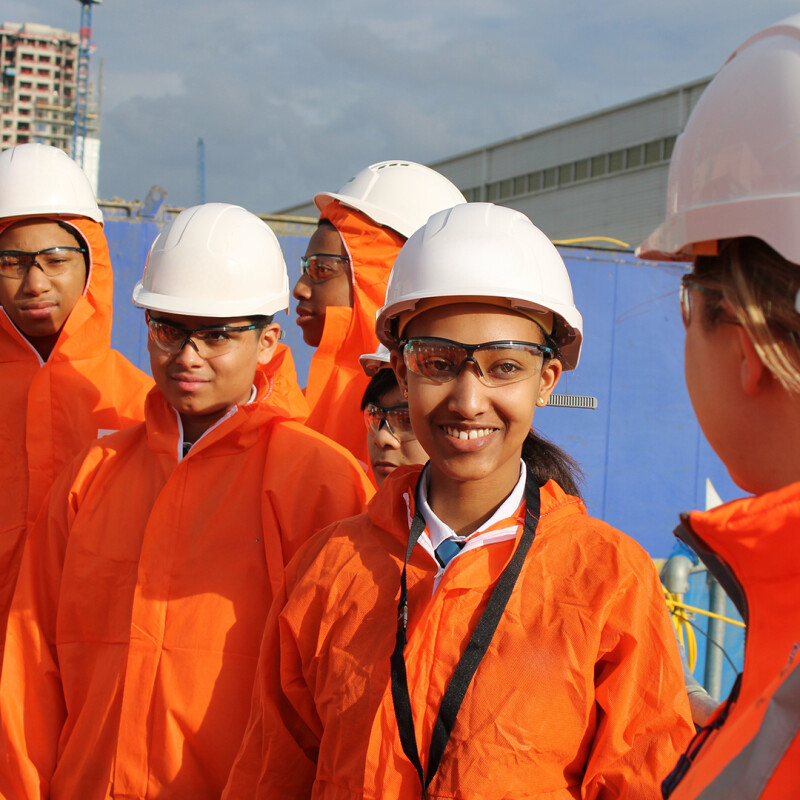Photo of a group of smiling young people wearing hard hats and high-vis jackets. (Brent Cross Town)