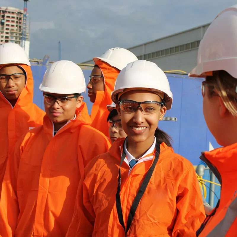 Photo of a group of smiling young people wearing hard hats and high-vis jackets. (Brent Cross Town)