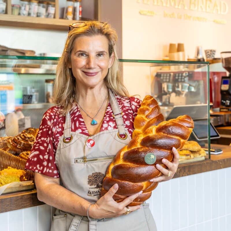 Photo of Tami from Karma Bakehouse in Brent Cross Town holding a loaf of bread. (Brent Cross Town)