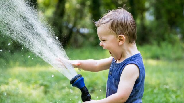 toddler playing with hose (Brent Cross Town)
