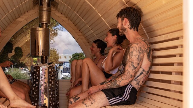 Photo of a group of people sitting inside a wooden sauna. (Brent Cross Town)