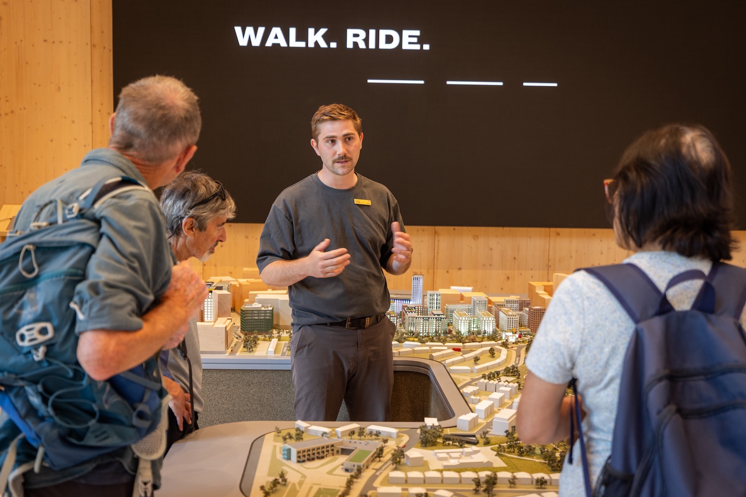 Photo of three people standing around a miniature scale model of Brent Cross Town in the Visitor Pavilion. (Brent Cross Town)